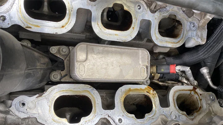 What causes oil in intake manifold
